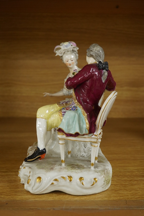 A Sitzendorf tete-a-tete porcelain figure group, signed to the base, 21cm high. Condition - fair, some losses and firing cracks